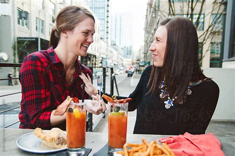 Young Beautiful Lesbian Couple Enjoying Drinks At An Outdoor Bar