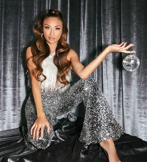 a beautiful woman sitting on top of a black leather couch next to a disco ball