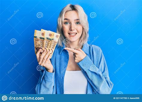 Young Blonde Girl Holding Hungarian Forint Banknotes Smiling Happy Pointing With Hand And Finger