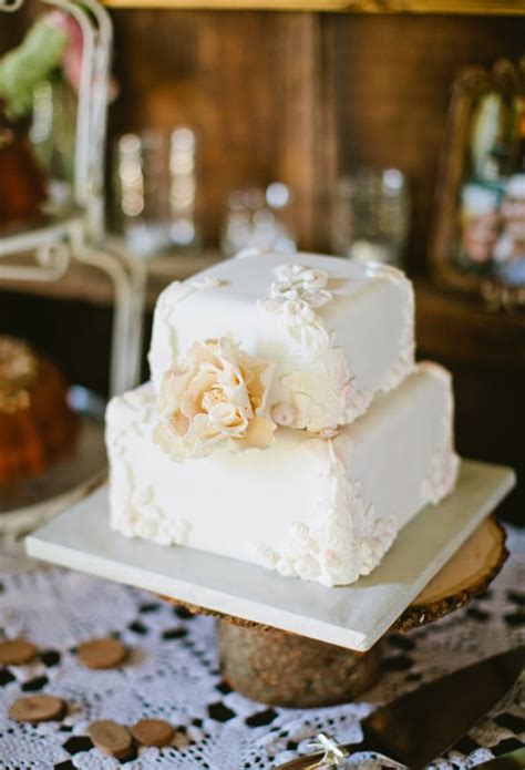 Stacking is the most architectural method of tiered cake construction. At only two layers high, this pretty white floral-covered ...