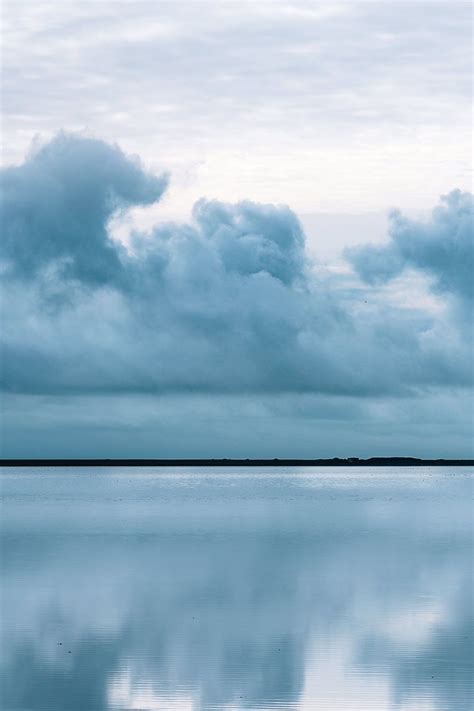 Minimalist Landscape Photograph Of Clouds Being Mirrored In A Calm Lake
