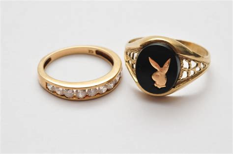 A 9ct Gold And Onyx Playboy Bunny Signet Ring Together With A 9ct