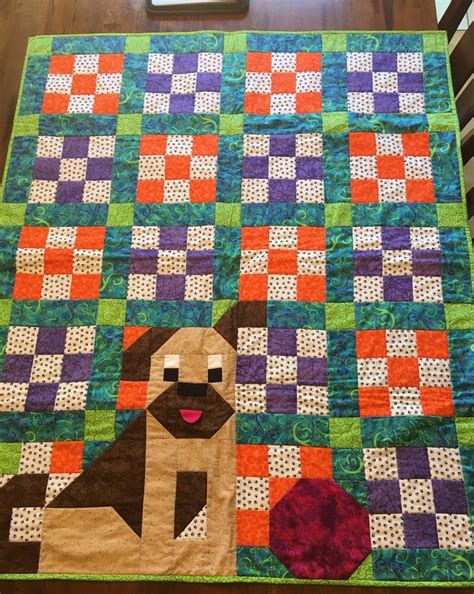 A Dog Is Sitting On Top Of A Quilt