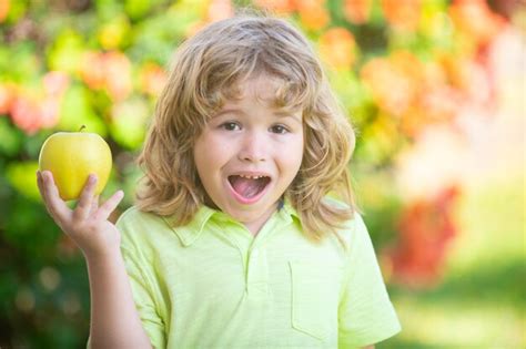 Heureux Petit Garçon Mangeant Une Pomme Verte Enfant Souriant Tenant