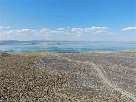 Aerial View Of Dusty Dry Desert Land With Mono Lake On The Background