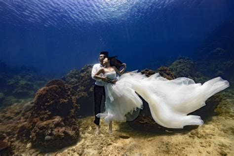 Bride And Groom Pose For Underwater Wedding Shoot