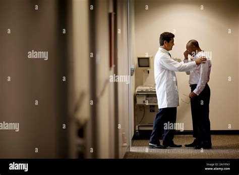 Doctor breaking bad news to man, standing in corridor Stock Photo - Alamy