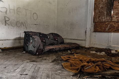 An Abandoned Room With Graffiti On The Wall And A Couch In The Corner