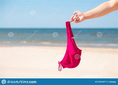 Close Up Of Young Woman Taking Off Her Bra At Nude Beach Concept Of