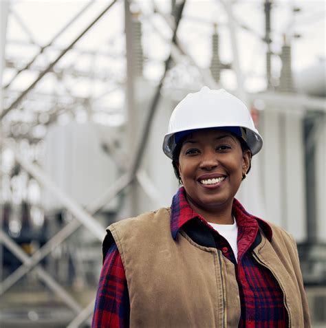 Woman Wearing Hard Hat In Front Of Power Station Portrait Tax