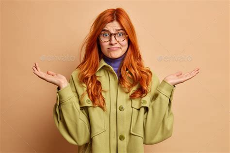 Human Perception Concept Doubtful Confused Hesitant Ginger Woman Raises Palms And Shrugs