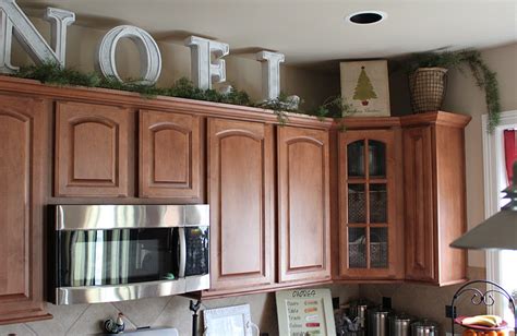 Big Letters And Pine Garland Above The Kitchen Cabinets