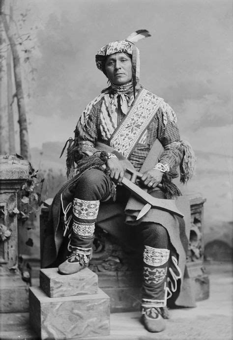 Bemos A Geshig Ojibwa Chief Wearing Traditional Dress And Holding