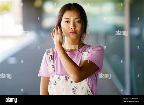 Young Asian female touching hair Stock Photo - Alamy