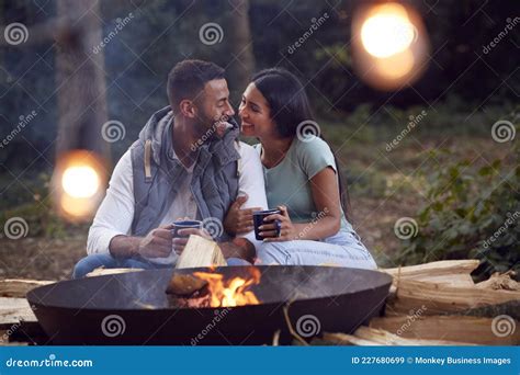 Romantic Couple Camping Sitting By Bonfire In Fire Bowl With Hot Drinks Stock Image Image Of