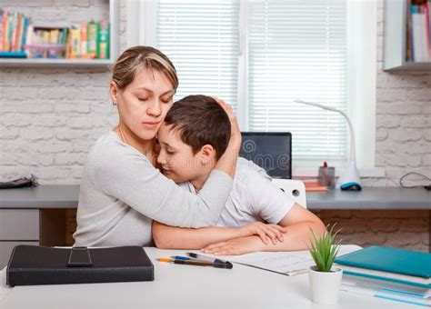 Mother Helping Her Son Making School Homework At Home Stock Image