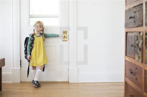 Girl Child Standing At A Door With A Book Bag — Photo — Lightstock