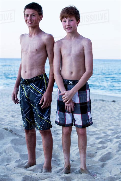 Portrait Of Two Boys Standing On Beach Stock Photo Dissolve