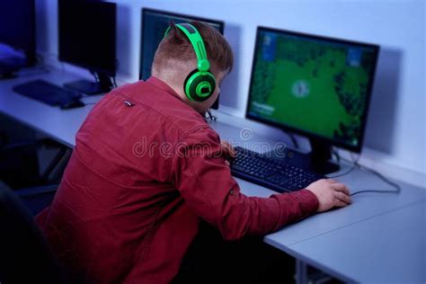 A Young Guy Is Focused On Playing Online Games On A Personal Computer