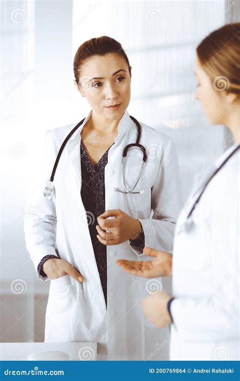 Two Female Physicians Are Talking About Medical Therapy While Standing