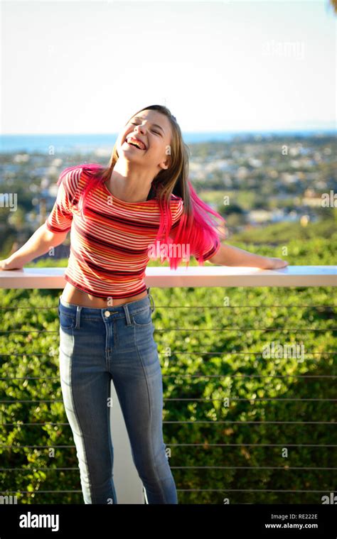 Tween Girl With Pink Hair And Jeans On Outside Balcony Is