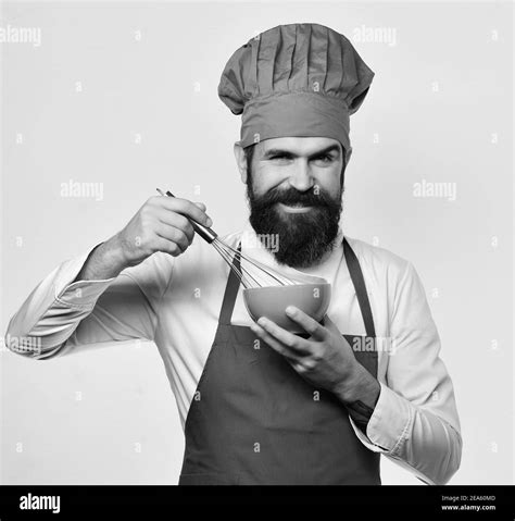 man with beard holds kitchenware on white background preparation process concept cook with