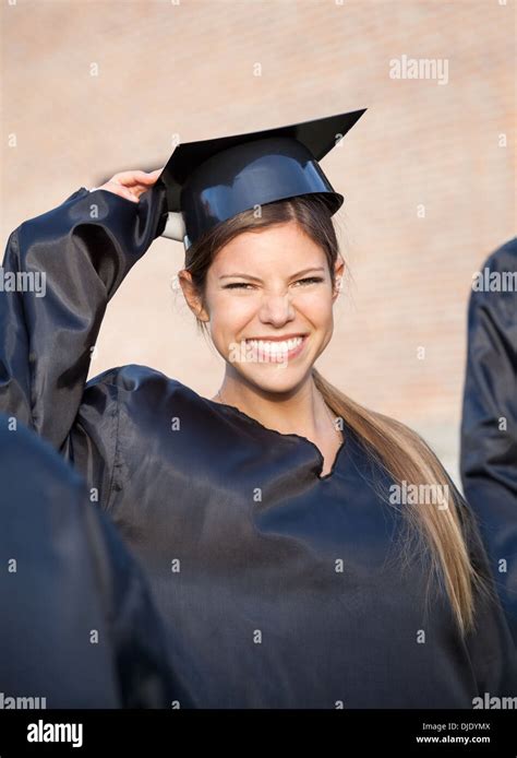 Woman In Graduation Gown Holding Mortar Board On Campus Stock Photo Alamy
