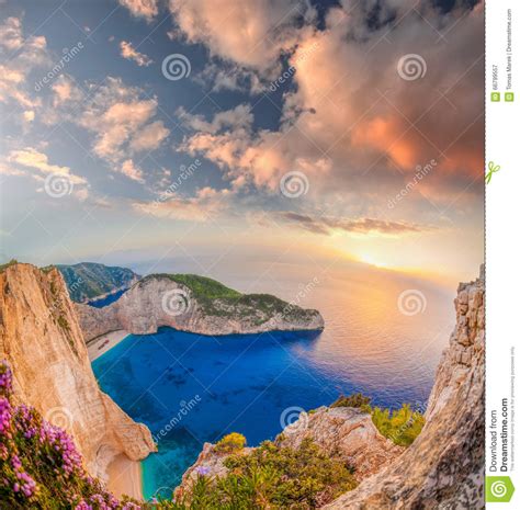 Navagio Beach With Shipwreck And Flowers Against Sunset On