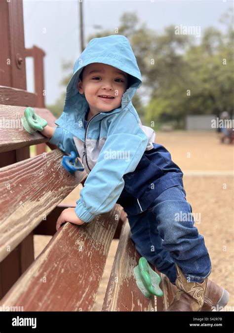 3 Year Old Little Boy Playing On Playground Equipment At A Park On An
