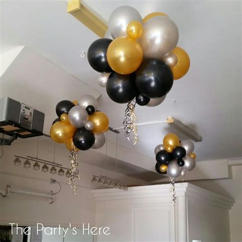 Black White And Gold Balloons Hanging From The Ceiling In A Partys Room