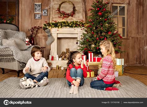 Kids Sitting On Carpet With Christmas Ts Stock Photo By