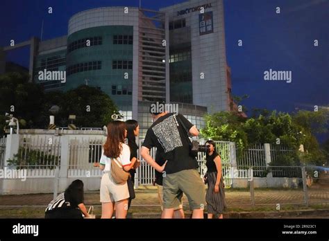 Some former journalists of Apple Daily take photos outside the