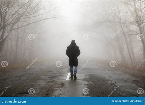 Fog Landscape Man Walking Alone On Scary Foggy Misty Road Stock Photo