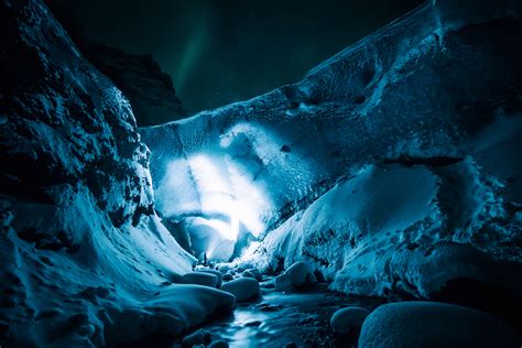 Man Exploring A Snow Cave 4k Uhd Wallpaper