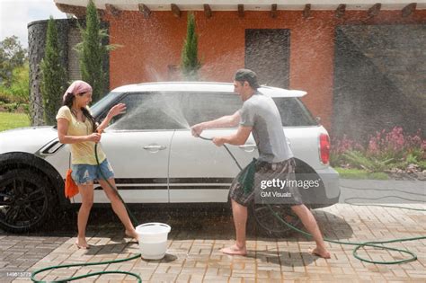 Playful Hispanic Couple Washing Car Together Photo Getty Images