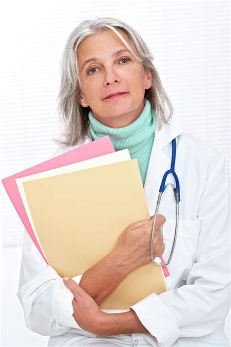 Mature Female Doctor Holding Files Photograph By Lea Paterson