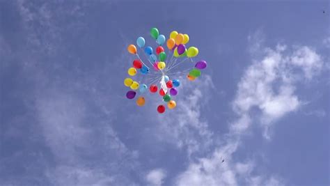 A Bunch Of Colourful Helium Filled Balloons Tied Together Flying