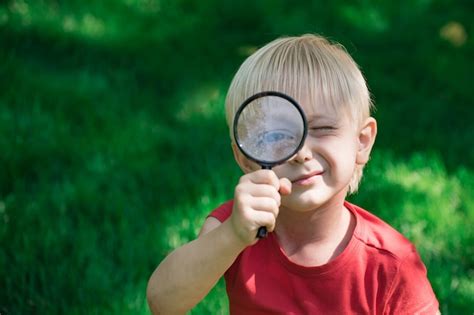 Premium Photo Little Boy Looking Through Magnifying Glass