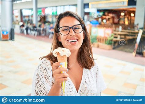 Young Beautiful Woman Eating Ice Cream Cone At The Shopping Center On A Sunny Day Of Summer On
