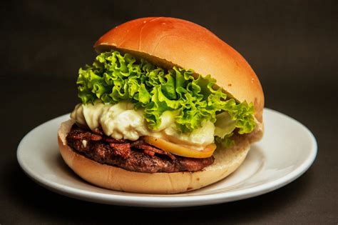 Burger With Lettuce And Cheese On A White Plate · Free Stock Photo