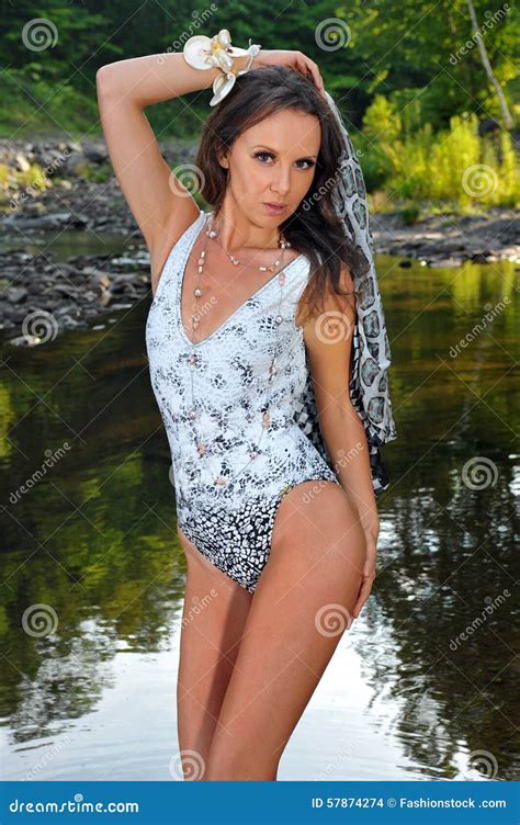 junge und sexy brunettefrau mit einem perfekten dünnen körper der in einem badeanzug aufwirft