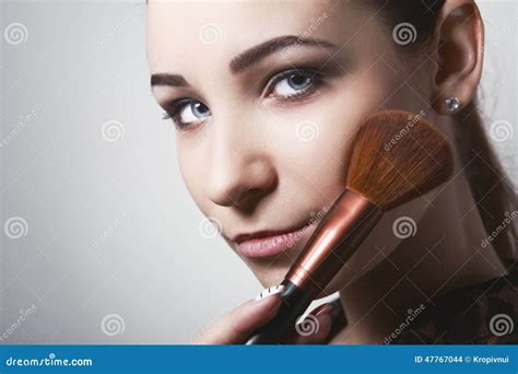 Beautiful Young Woman Holding Different Make Up Brushes Stock Photo