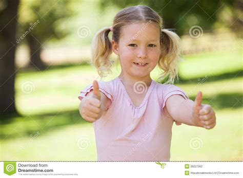 Smiling Girl Gesturing Thumbs Up At Park Stock Photo Image Of Camera