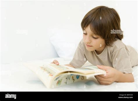 Boy Lying On Stomach Reading Book Stock Photo Alamy