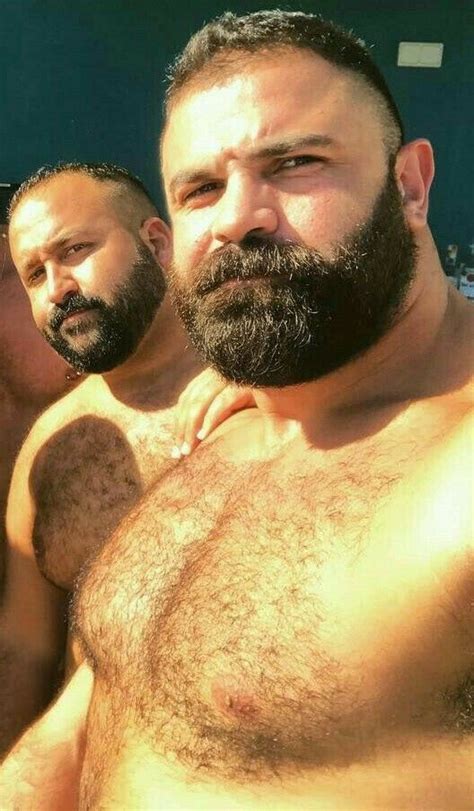 two men with beards standing next to each other