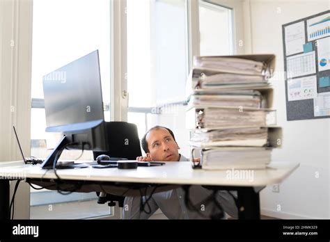 Overworked Business Man With Stack Or Pile Of Folders Stock Photo Alamy