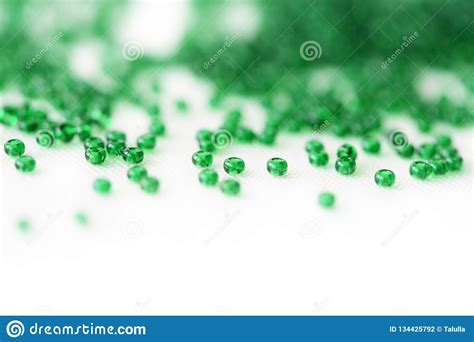 Green Color Seed Beads Scattered On Textile Background Stock Photo