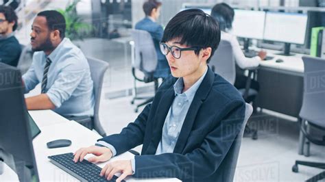 Young Professional Japanese Stock Broker Work On His Desktop Computer