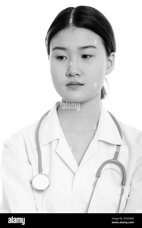 Studio Shot Of Young Beautiful Asian Woman Doctor Thinking While