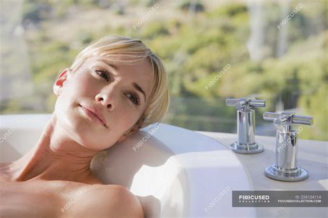 Close Up Of Woman Resting In Bathtub With Garden View On Background Tap Atmosphere Stock